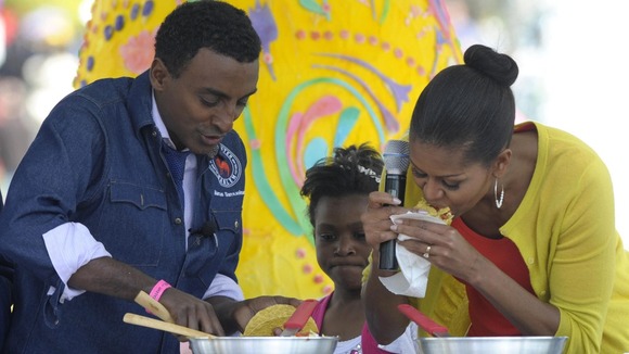 First lady Michelle Obama eats a taco made by chef Marcus Samuelsson during the annual White House Easter Egg Roll.