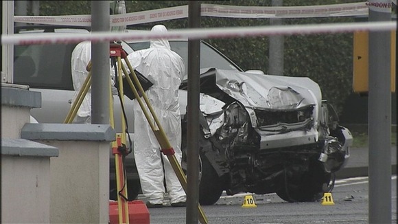 Forensic experts look at the stolen four-wheel-drive vehicle involved in the collision
