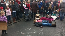 Children lie on road to protest closure