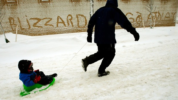 A man pulls his son in a sled in Boston, Massachusetts