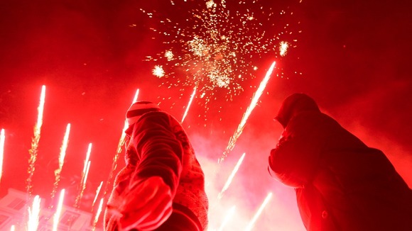 Residents watch after setting up fireworks as part of Chinese new year celebrations