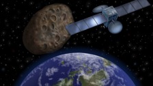 Artist's impression shows how the 'near-miss' asteroid might look passing in-between Earth and its communication satellites 