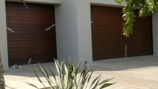 Broken police seals over the garage doors of the sports star's home 