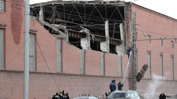 Workers repair damage caused after a meteorite passed above the Urals city of Chelyabinsk