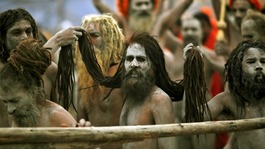 Naga Sadhus hold the hair of another Naga Sadhu on the banks of the Ganges  at the ongoing "Kumbh Mela"