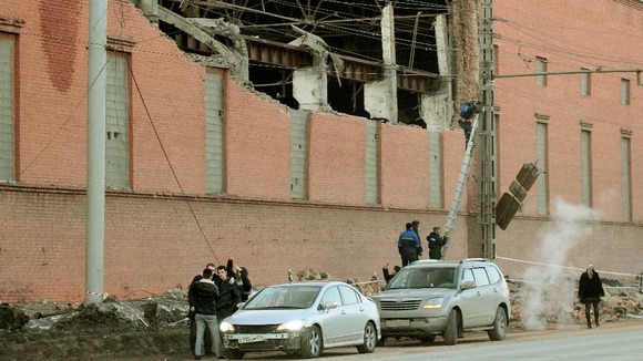 Workers repair damage caused after a meteorite shot across the sky