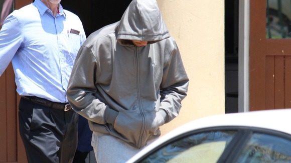Paralympic Athlete Oscar Pistorius leaves the police station following his arrest for allegedly shooting and killing his girlfriend.