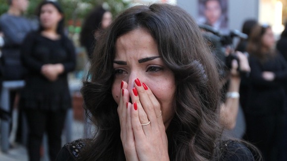 A colleague reacts as the coffin of Lebanese television cameraman Ali Shaaban of Al Jadeed TV.