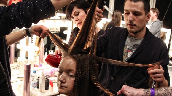 A model gets her hair prepared before the Marios Schwab Autumn/Winter London Fashion Week 2013 catwalk show