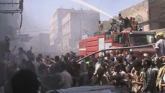 Crowds of people gather as firefighters try and put out the blaze.