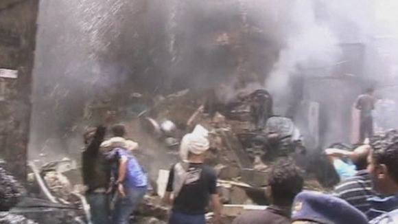 Locals try and help medics and firefighters at the crash site in Sanaa, Yemen.