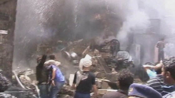 Locals try and help medics and firefighters at the crash site in Sanaa, Yemen.