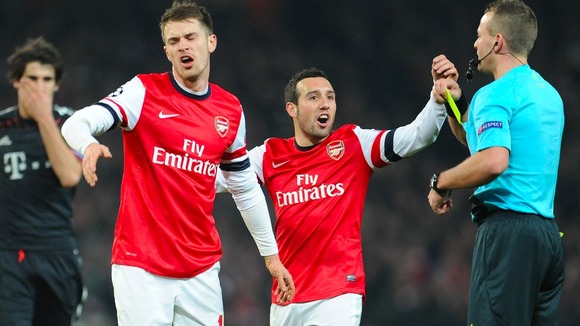 Aaron Ramsey and Santi Cazorla remonstrate with referee Svein Oddvar Moen