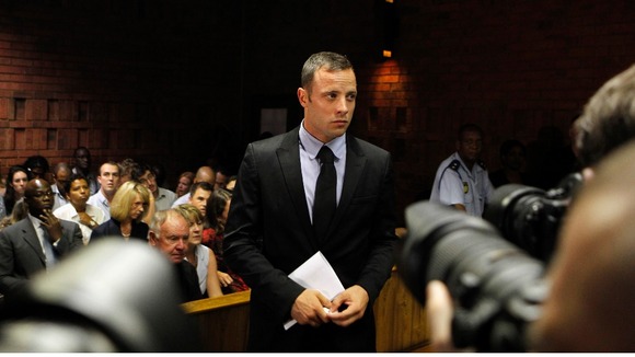 Photographers take pictures of Oscar Pistorius during a break in court proceedings