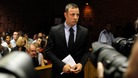 Photographers take pictures of Oscar Pistorius during a break in court proceedings