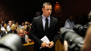 Photographers take pictures of Oscar Pistorius during a break in court proceedings