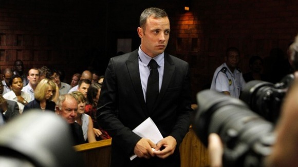 Photographers take pictures of Oscar Pistorius during a break in court proceedings