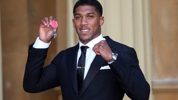 Olympic Gold Medalist Anthony Joshua proudly holds his Member of the British Empire (MBE) medal
