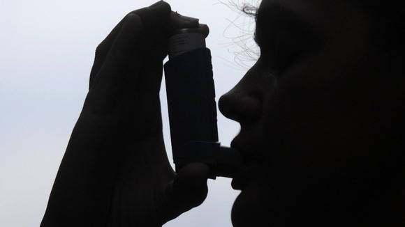 Patient using an inhaler to treat asthma
