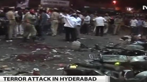 Police and citizens survey the aftermath of one of the blasts
