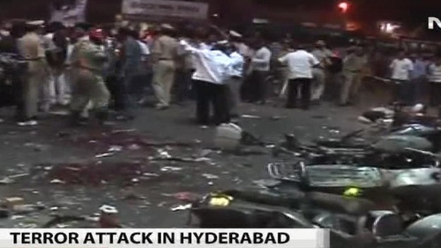 Police and citizens survey the aftermath of one of the blasts