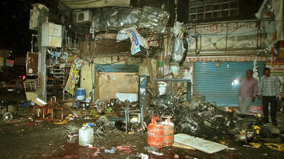 Investigating officers inspect the site of one of the explosions