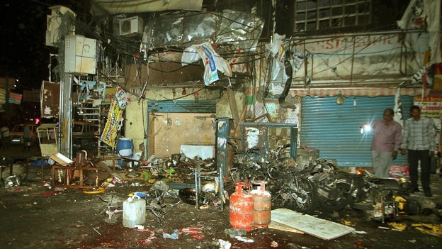 Investigating officers inspect the site of one of the explosions