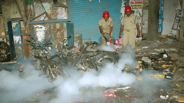 Firefighters extinguish a fire at the site of one of the explosions