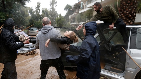 A woman is pulled to safety in Athens today.