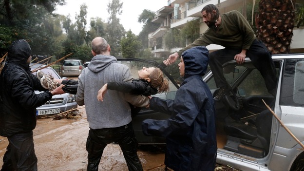 A woman is pulled to safety in Athens today.