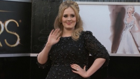 Singer Adele waves to fans on the red carpet