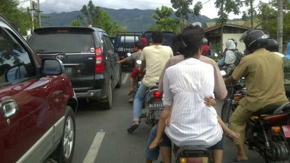 People riding motorbikes and cars packed the street in Banda Aceh after a strong earthquake struck Indonesia