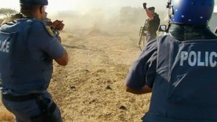 Police fire at striking miners outside a South African mine owned by Lonmin's of London
