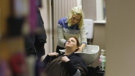 Lady washes hair in a salon