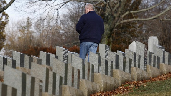 A visitor stands amid the gravestone of Titanic victims in Fairview Lawn Cemetery in Halifax