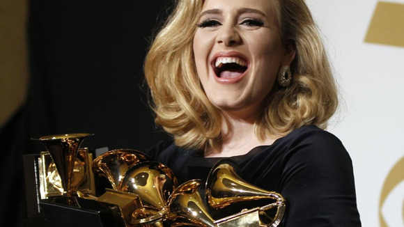 Singer Adele holds her six Grammy Awards at the 54th annual Grammy Awards in Los Angeles