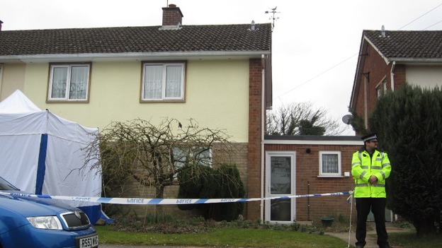 A police officer stands guard outside the property where the two bodies were discovered 
