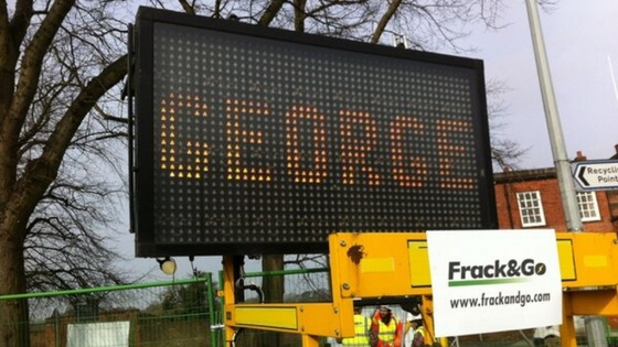 Electronic signs have been placed alongside a mock drilling rig.