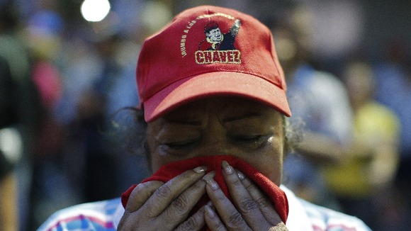 A mourners outside the hospital holding the body of Hugo Chavez