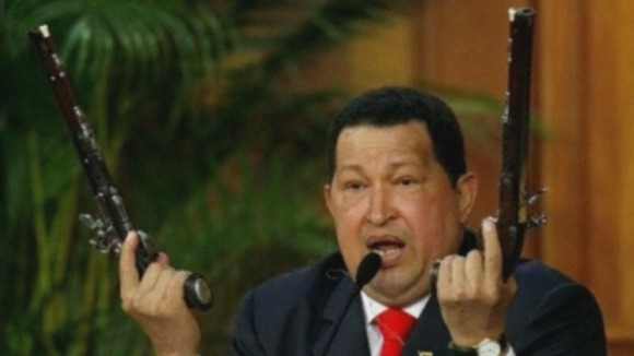 Hugo Chavez wields two guns which used to be owned by Simon Bolivar