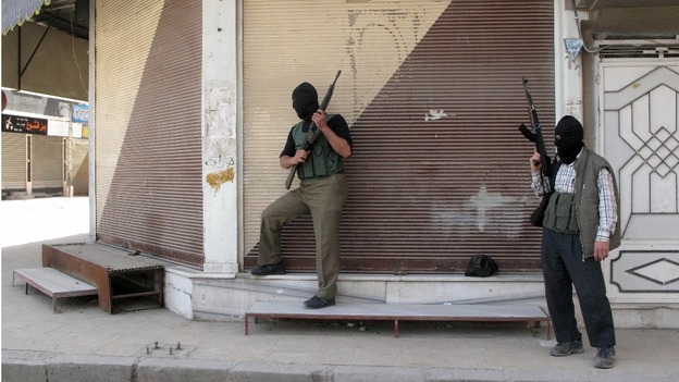 Free Syrian Army fighters stand guard during fighting with Syrian troops in a suburb of Damascus