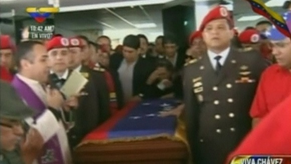 A priest leads a short service in honour of the former president