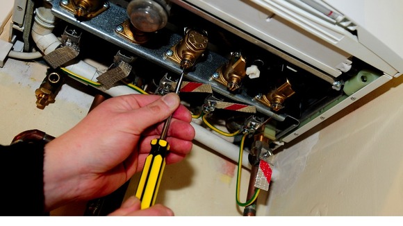 A plumber working on a gas boiler.