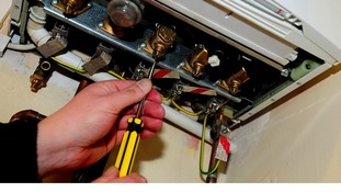 A plumber working on a gas boiler.