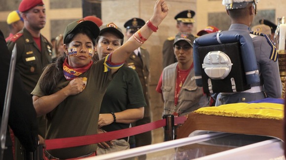 A supporter salutes as the body of Hugo Chavez lies in state