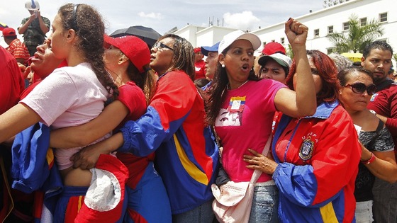 Mourners stand in line to view his body in state at the Military Academy in Caracas