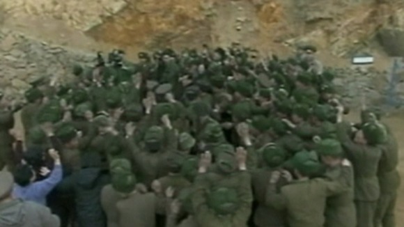 Kim Jong-un can barely be seen amongst the cheering crowd of soldiers