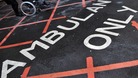 A patient is pushed in a wheelchair at a hospital in central London