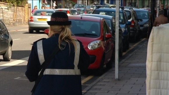 female traffic warden and parked cars