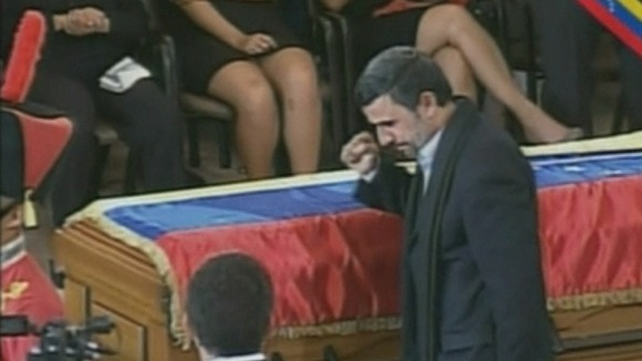 Iran's President Mahmoud Ahmadinejad gestures to the other guests at the funeral
